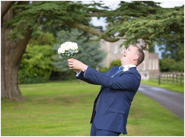 fun wedding photo of groom with bride's bouquet