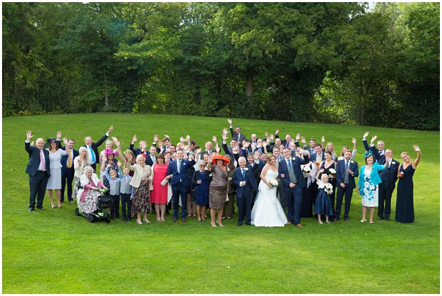 group photo of wedding guests at Wasing Park