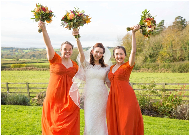 bridesmaids wearing orange dresses at Hyde Barn wedding