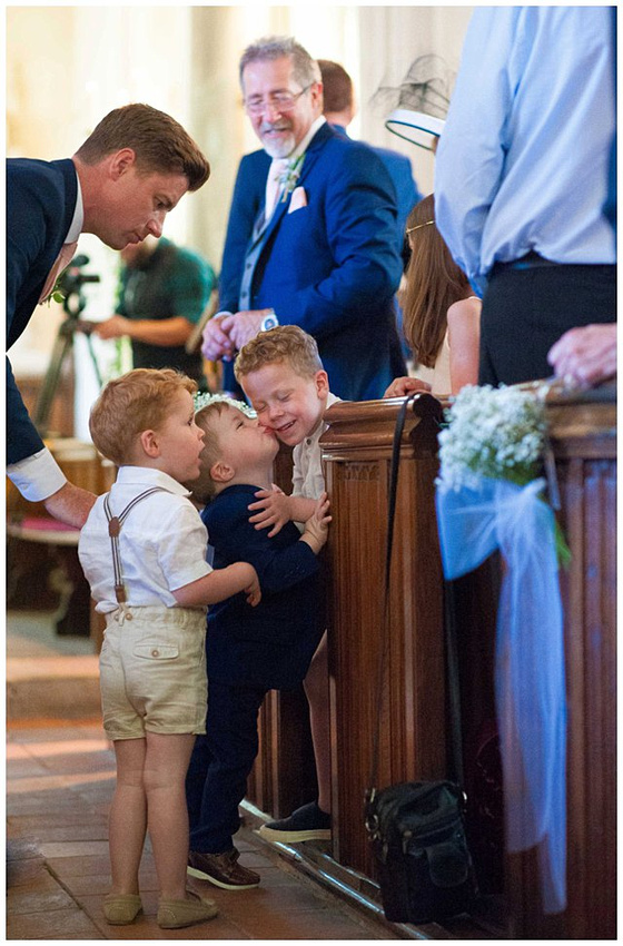 candid photo of ring bearer during wedding ceremony at St. Mary Magdalene Church for Hampden House wedding