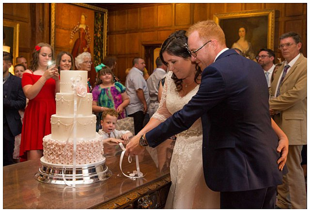 bride and groom cutting wedding cake at wedding reception at Hampden House