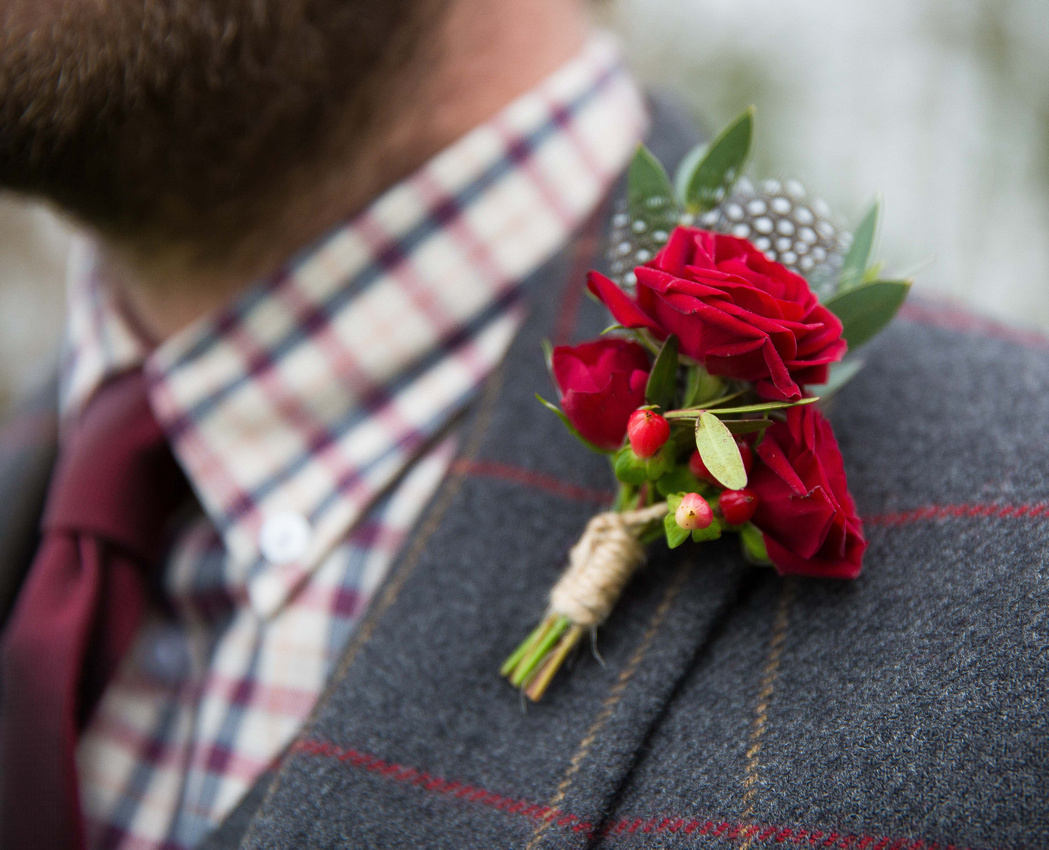 grooms buttonhole featuring red roses